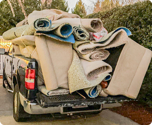 EasyGig Junk Removal truck loaded with a couch, carpet, and general junk.