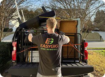 EasyGig Junk Removal team member securing furniture in a pickup truck for residential curbside removal.