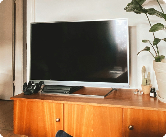 Old flat screen TV resting on an entertainment center.