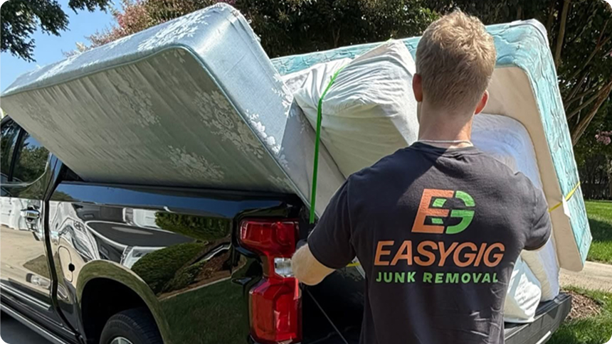 EasyGig hauler loading mattresses and box springs into a pickup truckload for junk removal and donation