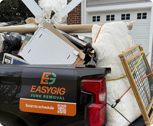 EasyGig pickup truckload filled with bulky furniture, mattresses, and large household items for junk removal