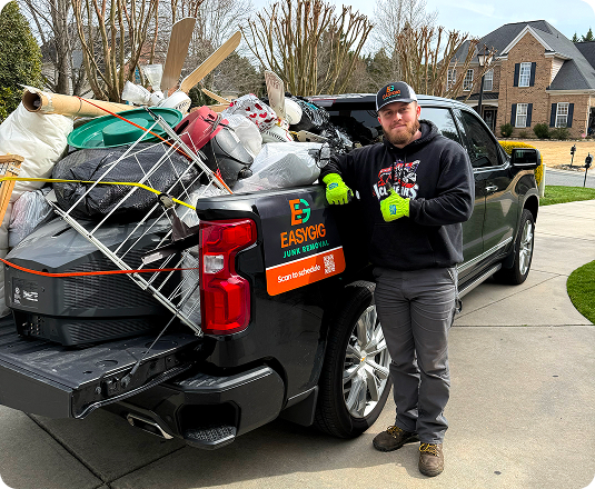 EasyGig Junk Removal Hauler next to a loaded truck with household junk.