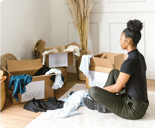 Woman sorting through her items determining which to keep, donate, and set for junk removal