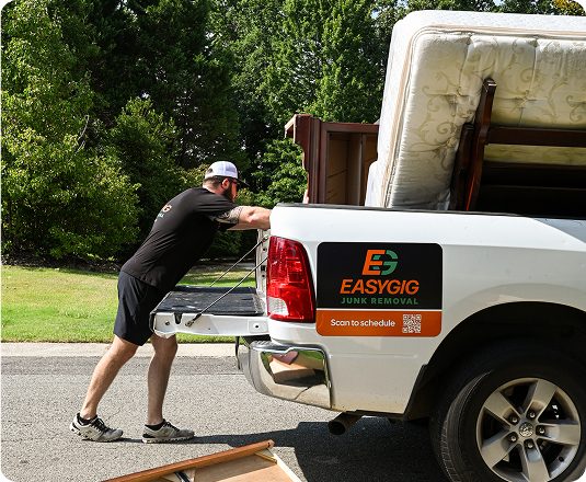 EasyGig Junk Removal Hauler loading up his pickup truck with curbside general household junk.