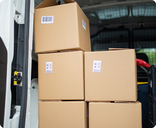 Stacked cardboard moving boxes loaded into the back of a van during a home move-out