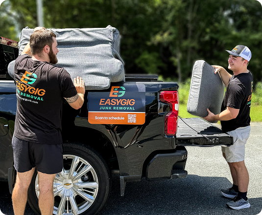 Two EasyGig Junk Removal Haulers having fun while loading up a pickup truck.