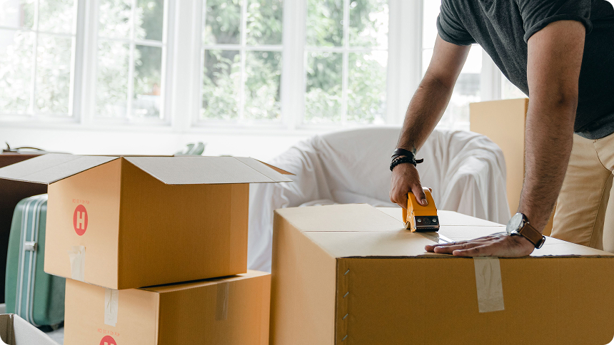 Man packing up moving boxes during a unit turnover.